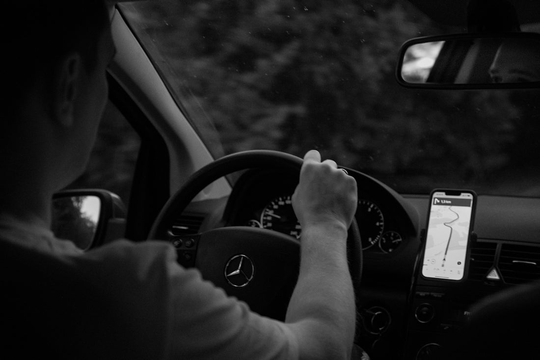 Person driving a car with gps navigation on phone.